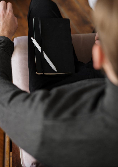 man with notepad on lap